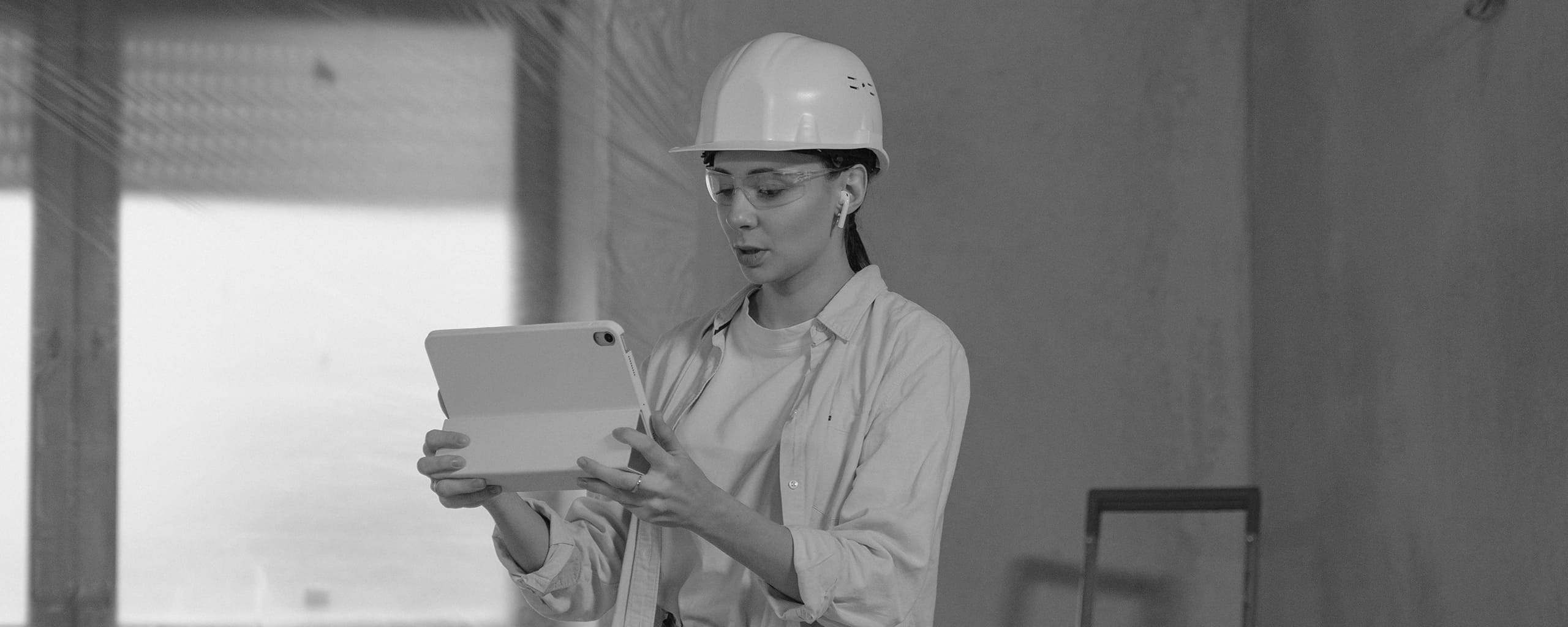 Junge Frau auf der Baustelle mit Tablet in der Hand
